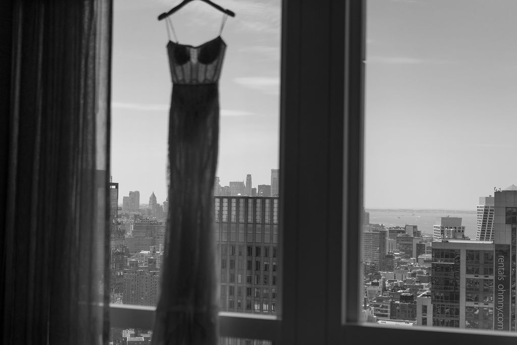 Wedding dress hung up over New Jersey City skyline