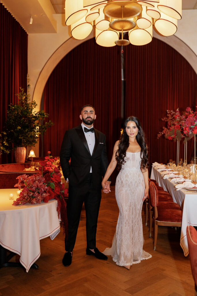 Bride and Groom standing front of image with Well-Dressed Events designed venue behind 