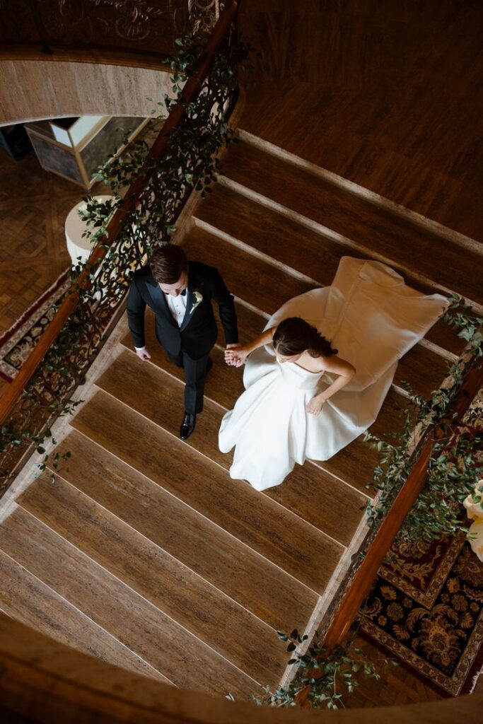 Newlywed couple walking up the staircase at a luxury New Jersey wedding venue, showcasing intentional wedding planning and elegant wedding photography.