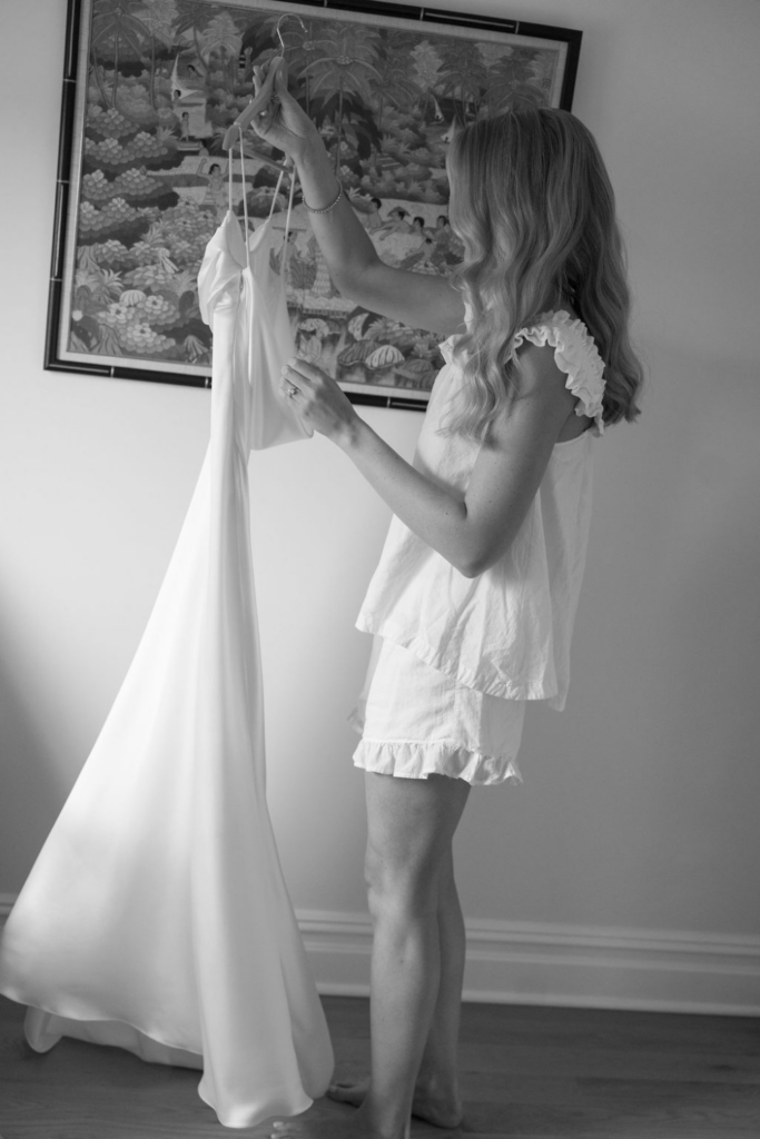 Bride holding up her wedding dress while getting ready before the ceremony