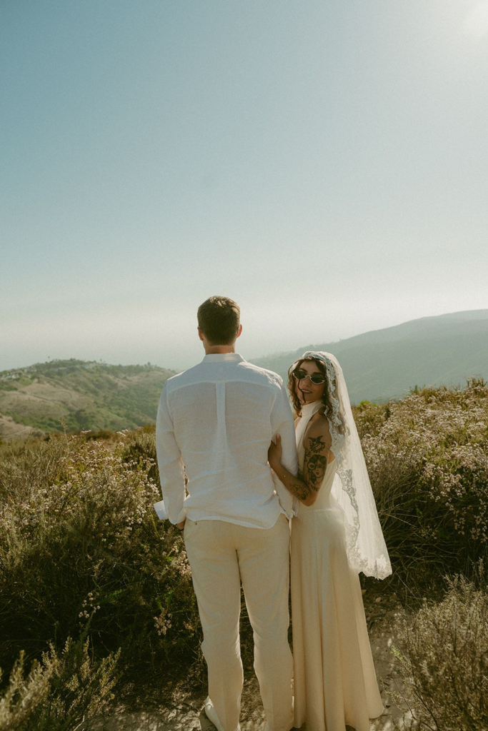 Bride and groom posing on the staircase of a Southern California-style wedding venue before their ceremony.